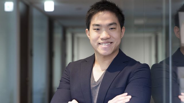腕を組んでいながら笑う男性の姿