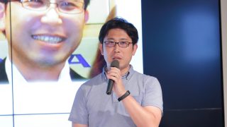 男性がマイクを持って発表している