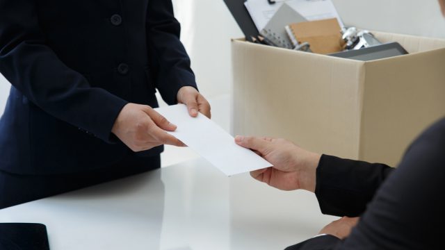 Businesswoman with a brown cardboard box and sending a resignation