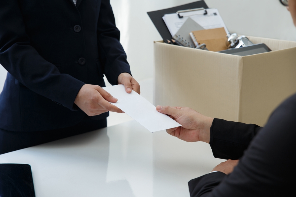 Businesswoman with a brown cardboard box and sending a resignation