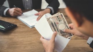 Businessman counting money japanese yen currency in envelope