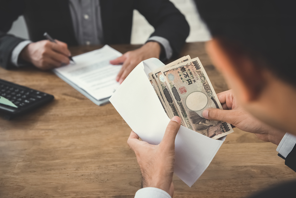 Businessman counting money japanese yen currency in envelope