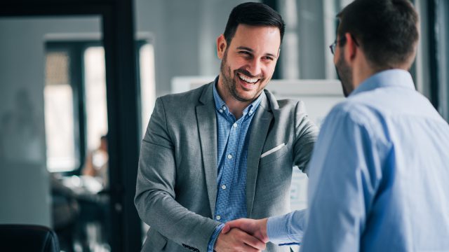 Portrait of cheerful young manager handshake with new employee