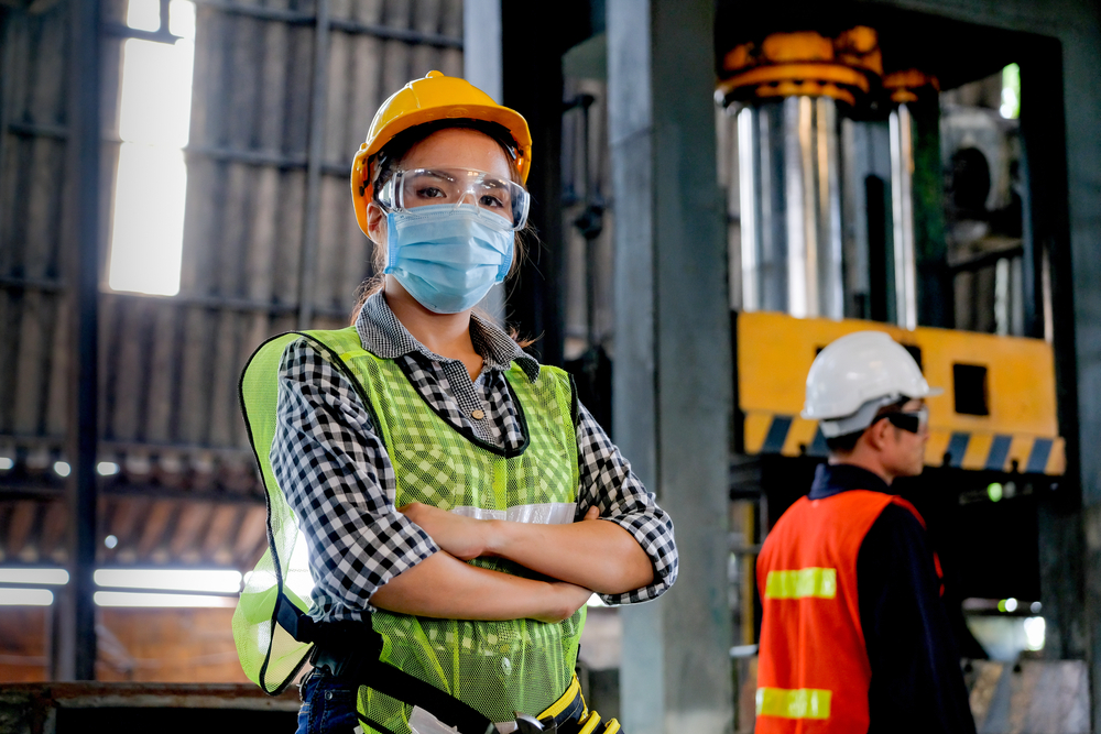Factory woman worker or technician with hygienic mask standing